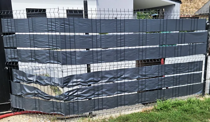 Rovnaký plot zblízka — materiál stratil pevnosť aj farbu.